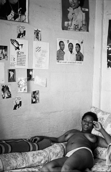A woman relaxing on a bed after a long day, Alexander Hostel